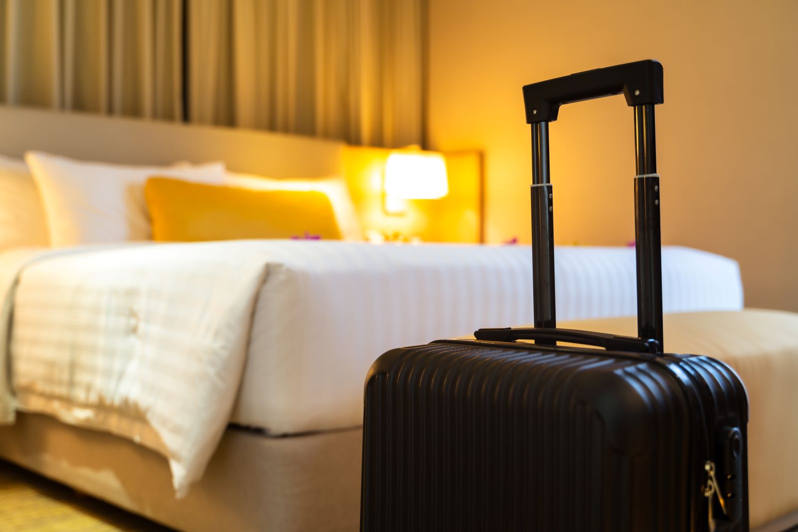 Quarto de hotel com mala de viagem ilustram comodidade que o SiTef traz para os hóspedes