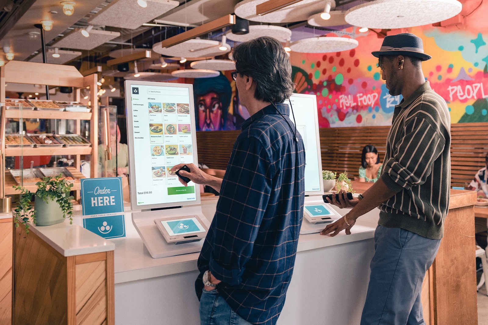 Clientes fazendo pedido em restaurante utilizando a Clover Kiosk